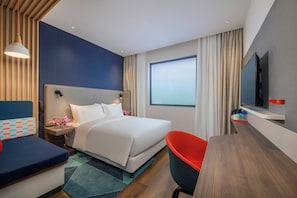 A modern hotel room with a large bed, a desk, a chair, a TV, and a window with curtains. - Holiday Inn Express Shanghai Xuhui Binjiang (Shanghai)