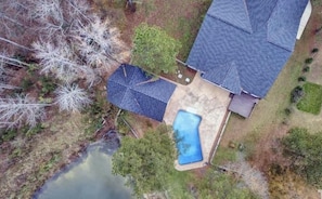An aerial view of a house with a swimming pool, a covered patio, and a small pond. - Private Pool with Pond Views - Pet Friendly - Near Downtown (Fuquay-Varina)