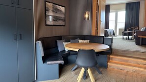 A modern living room with a dark gray sofa, a wooden coffee table, and a black chair with wooden legs. - Only 100 m to the beach, apartment with balcony - App. Eldena FeWo 15 - Apartments (Middelhagen)