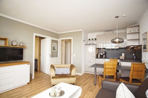 A modern apartment with a living room, dining area, and kitchen.