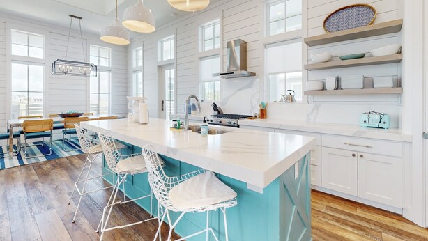 A modern kitchen with a large island, bar stools, and pendant lighting. - Chic Sunset Views on Palmilla Golf Course, Designer Interior & Chef’s Kitchen (Port Aransas)