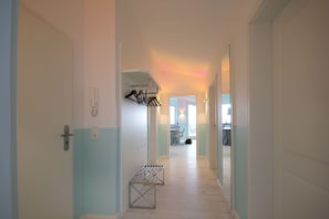 A hallway with a bench, a coat rack, and a door with a lock. - With a view of the sea and a balcony, access to the pool and sauna - Sea View Apartment 67 - (Göhren)