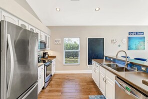 A modern kitchen with stainless steel appliances, a built-in oven, and a dishwasher. - Pool Home Near Beaches and Downtown 5th Ave. (Naples)