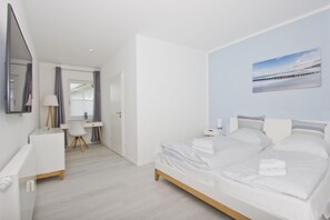 Une chambre moderne avec un grand lit, un bureau et une chaise.