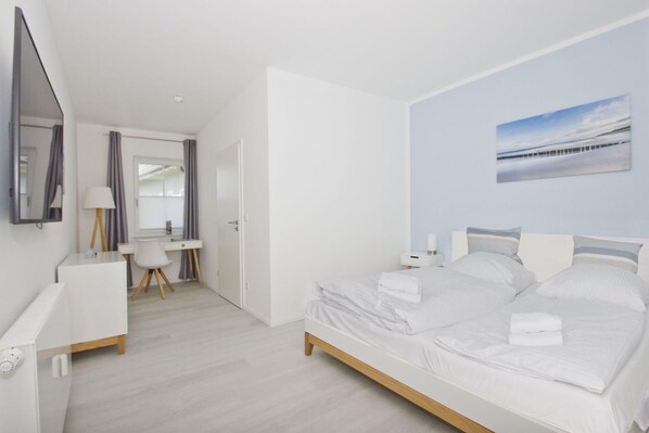 Une chambre moderne avec un grand lit, un bureau et une chaise.