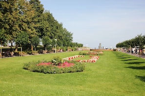 Un parque con césped, parterres de flores y árboles.