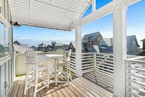 Enjoy a meal or relax on the covered deck with a table and chairs, surrounded by a view of the neighborhood.
