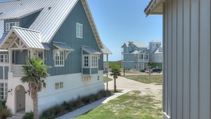 A coastal residential area with large, blue houses featuring prominent gable roofs and white trim.