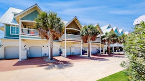 A resort with multiple-story buildings, balconies, and palm trees. - Luxe Palmilla townhome with resort pool & golf - walk to beach (Port Aransas)