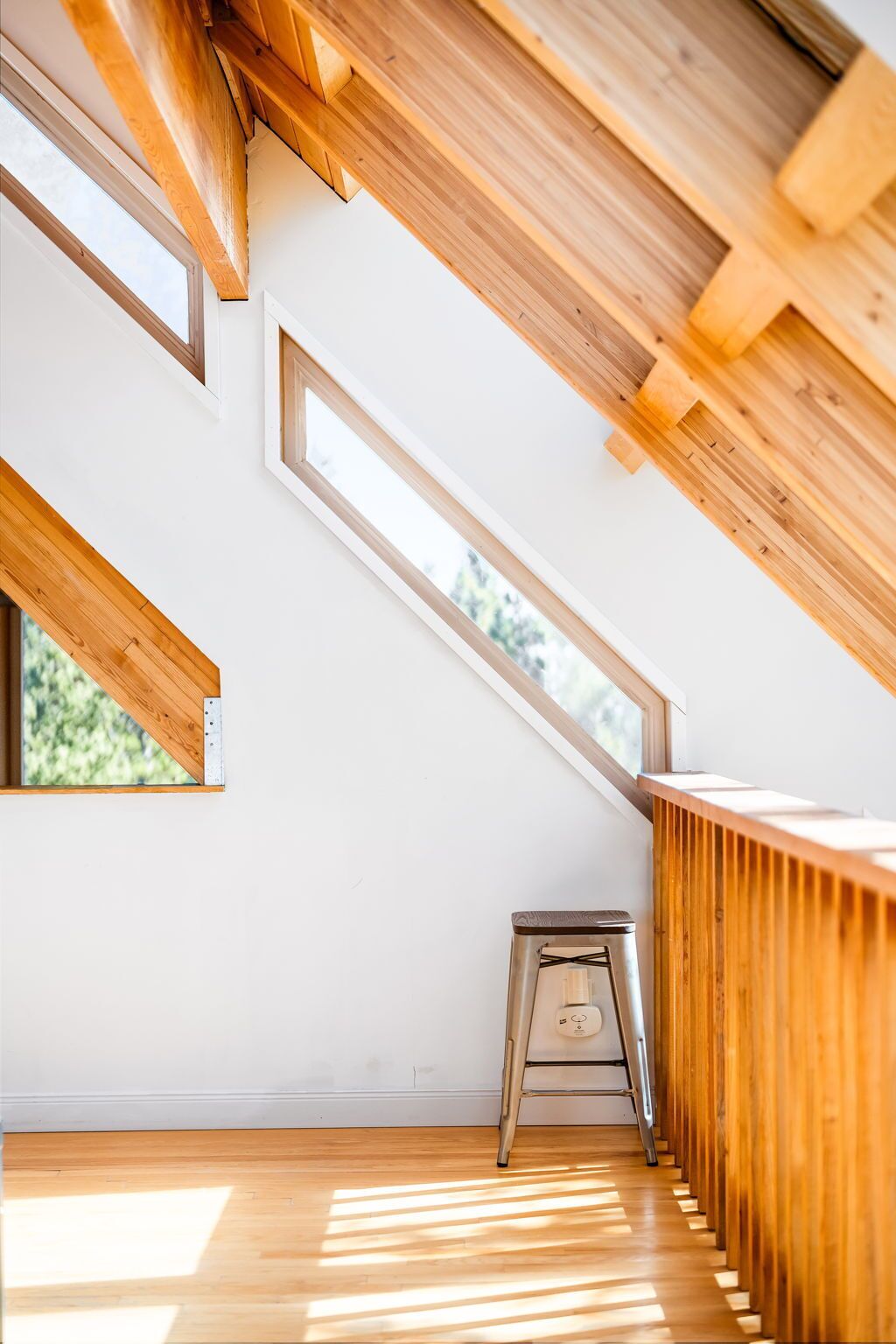 A room with a sloped ceiling, skylights, and a wooden bench.