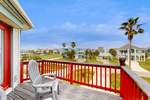 Enjoy the serene view from this deck overlooking a residential area with palm trees.