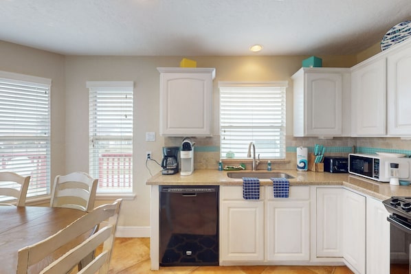 Enjoy cooking in this well-equipped kitchen with a central island, dishwasher, coffee maker, microwave, and stove.