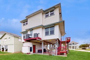 Stunning two-story home with a central entrance, covered porch, and beautifully manicured lawn.