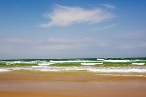 Une plage avec des vagues et un ciel dégagé.