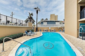 A swimming pool with a palm tree and lounge chairs. - Beachfront Condo w/ Pool, Balcony & Stunning Gulf Views - Steps to Beach (South Padre Island)