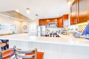 Enjoy cooking in this well-equipped kitchen with a spacious island, stainless steel appliances, and a dining area.