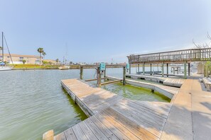 Une jetée en bois s’étendant dans une étendue d’eau calme, avec une passerelle en bois et une zone abritée.