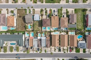Vista aérea de una zona residencial con varias casas, cada una con piscina.