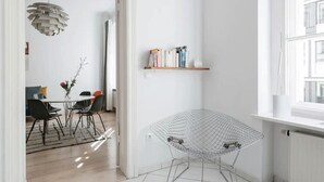 A modern living space with a dining area, a wireframe chair, and a bookshelf. - Top Luxury Space Spree Mitte Berlin (Berlin)