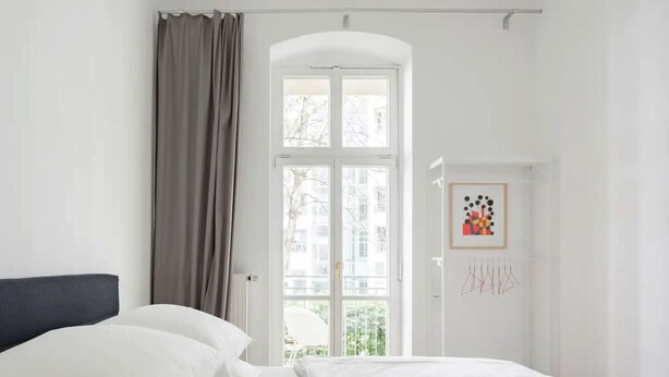 A hotel room with a bed, a window, and a door with artwork. - Top Luxury Space Spree Mitte Berlin (Berlin)