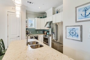 Enjoy cooking in this kitchen with a double sink, refrigerator, and oven, plus a window with blinds.