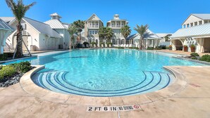 A swimming pool with a 2 ft 6 in no diving depth marker, surrounded by a poolside area with lounge chairs and palm trees. - Perfect Palmilla Beach Townhome | Near Resort Pool, Beach Access & Golf (Port Aransas)