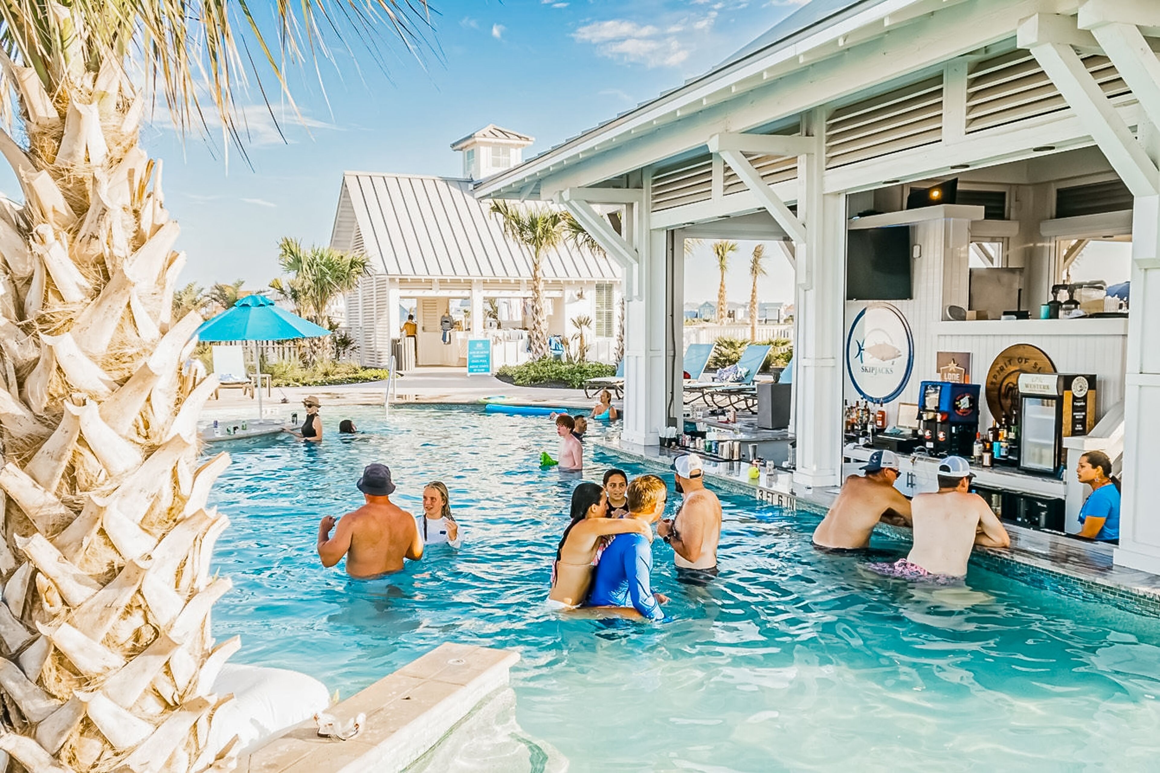 A pool area with a bar and lounge chairs. - Upscale townhouse near the pool with bikes, resort boardwalk & golf course (Port Aransas)