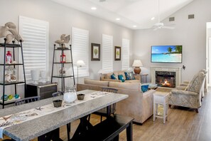 Relax in the living room with a comfortable sofa, flat-screen TV, and dining area.