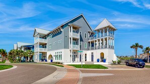 A large, modern two-story building with a prominent balcony and a garage.