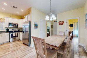 Enjoy meals in this kitchen with a dining table and pendant light, opening into a spacious dining area with a view.