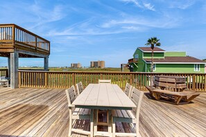 Guests can enjoy meals and relaxation on the deck, surrounded by lush surroundings and a scenic view.
