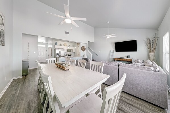 A modern living space with a dining area, kitchen, and seating area.