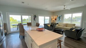 A spacious living area with a large island, a sofa, and a dining table. - Latitudes - Ocean front with salt water pool. (Cudjoe Key)