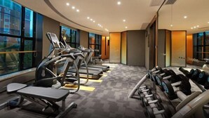 Un gimnasio moderno con cintas de correr, mancuernas y bancos de pesas.