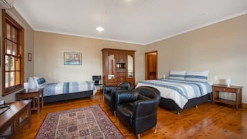 Relax in a spacious bedroom with a large bed, wooden wardrobe, and comfortable seating area.