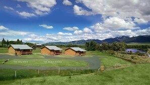 A rural property with three wooden cabins labeled "The Big Hole" and "The Beaverhead." - River Rest Luxury Cabin - The Big Hole. Beautiful River and Mountain Views!! (Silver Star)