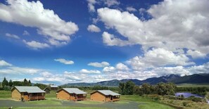 A rural property with three wooden cabins labeled "The Big Hole" and "The Beaverhead." - River Rest Luxury Cabin - The Ruby. Beautiful River and Mountain Views!! (Silver Star)