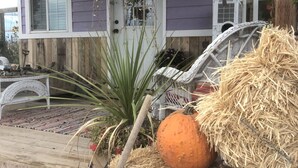A porch with hay bales, pumpkins, and a hanging planter. - The Chick Inn<br>Bed Breakfast and Dinner!!! (Eagle Mountain)