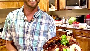 A person holding a large platter of food in a kitchen with wooden cabinets and a microwave. - The Chick Inn<br>Bed Breakfast and Dinner!!! (Eagle Mountain)