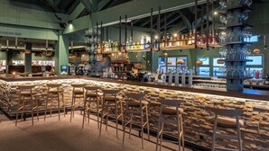 A bar area with stone walls, wooden bar stools, and shelves of bottles and glasses. - La Rosiere (Montvalezan)