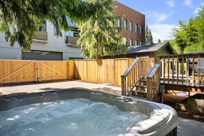 A backyard with a hot tub, wooden deck, and a fenced area. - Pristine Renovation w/ Epic Location, Pet Friendly, Fully Fenced, Hot Tub, Walk to Bars, Shopping (Portland)