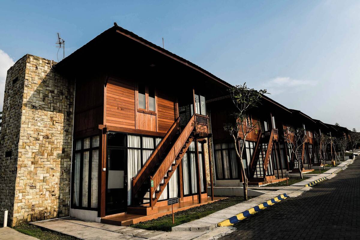 A row of modern buildings with wooden facades and large windows.