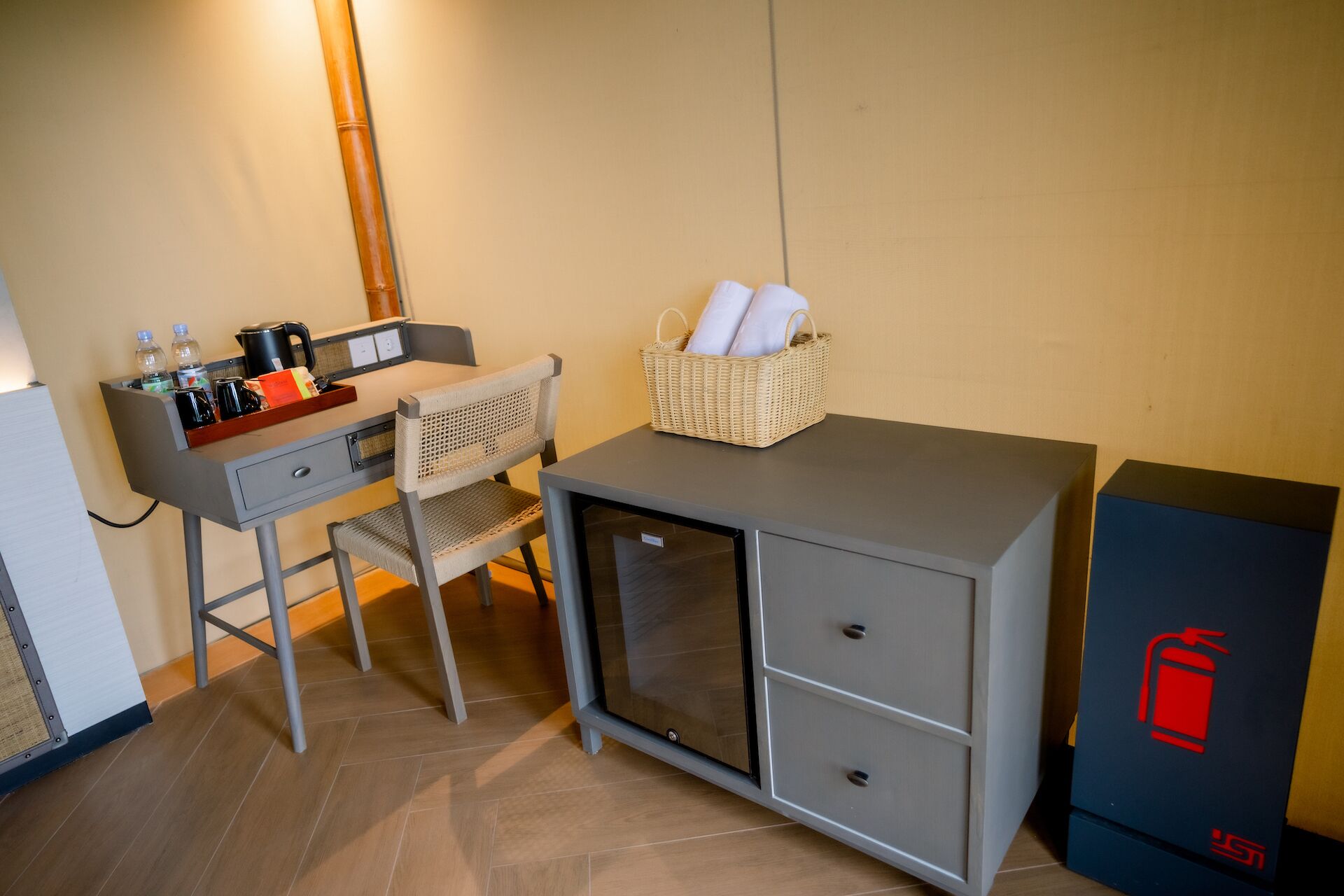 Een kleine, praktische kamer met een bureau, stoel en een minibars.