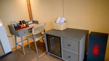 Een kleine, praktische kamer met een bureau, stoel en een minibars.