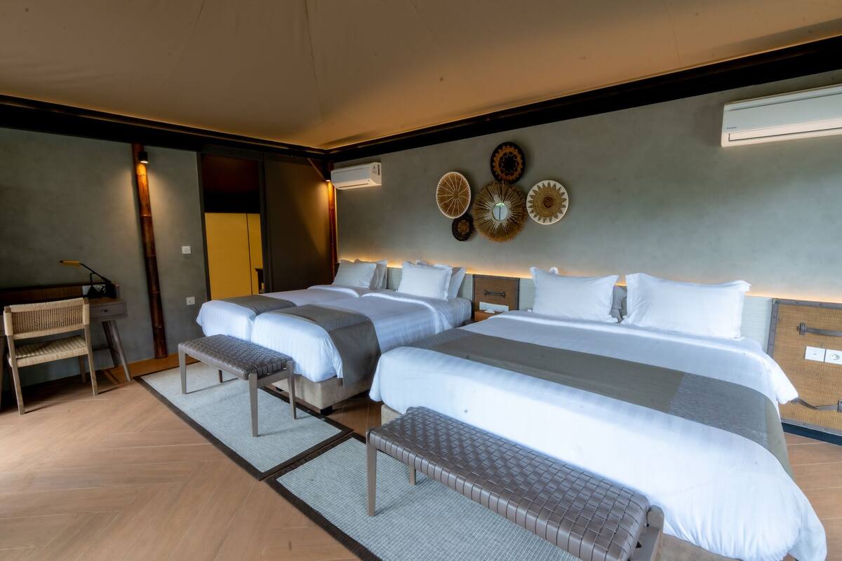 A hotel room with a large bed, a desk, and a chair.