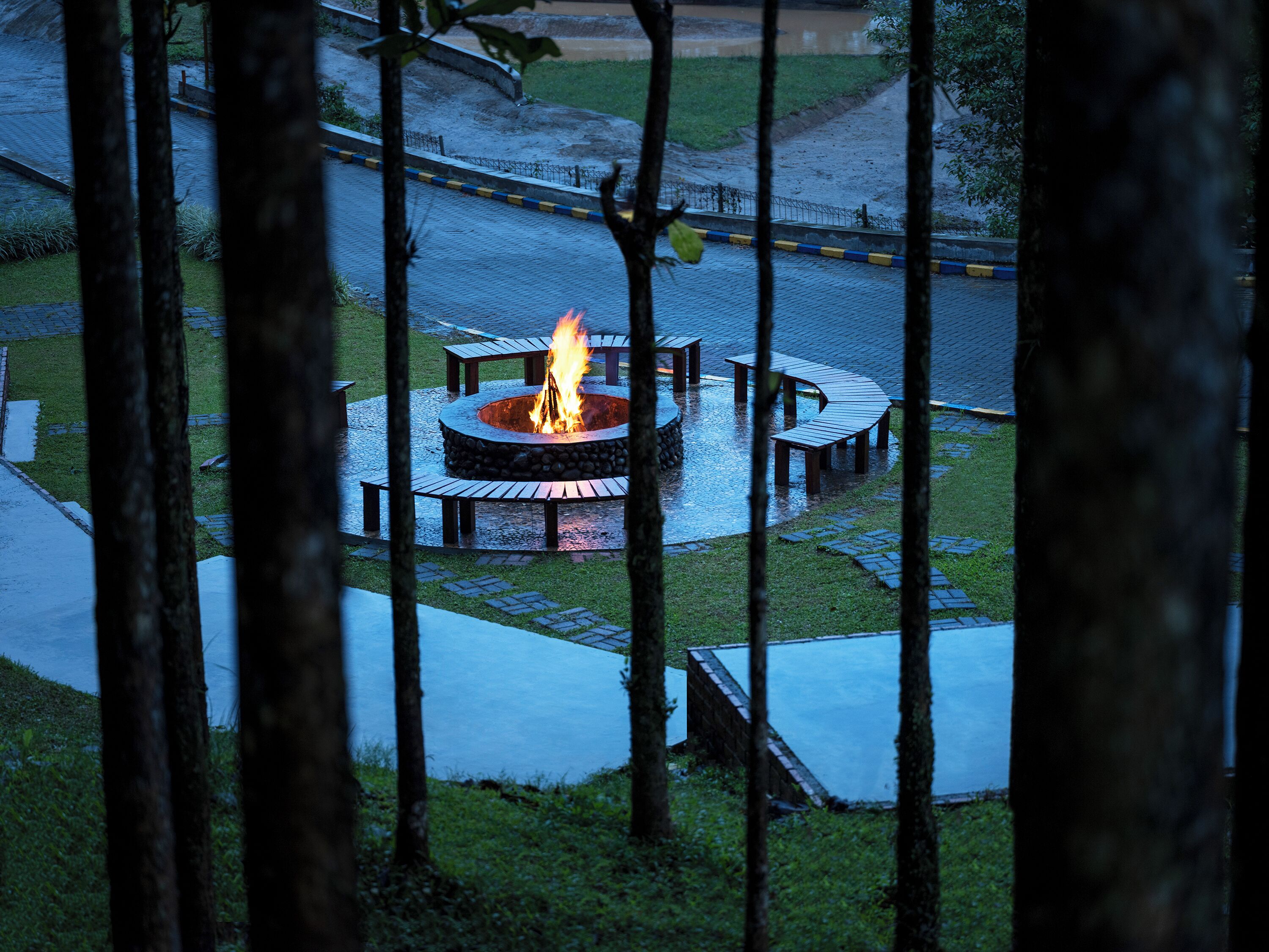 A circular outdoor seating area with a central fire pit surrounded by benches.