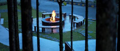 A circular outdoor seating area with a central fire pit surrounded by benches.