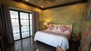Une chambre d’hôtel avec un grand lit, une chaise et une vue sur l’extérieur grâce à une porte en verre à motifs.