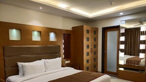 Una habitación de hotel moderna con una cama grande, un armario y un espejo.
