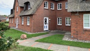 A brick house with a thatched roof, a small front garden, and a paved driveway. - Daggys Huus - Holiday home Daggy (Nordstrand)